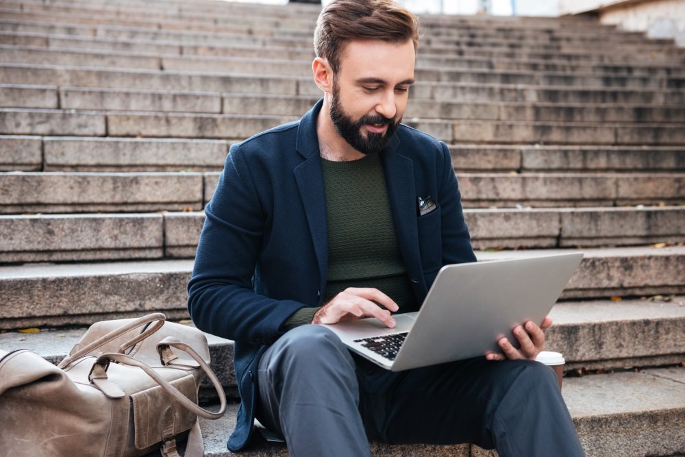 Man using a laptop and sit in stairs